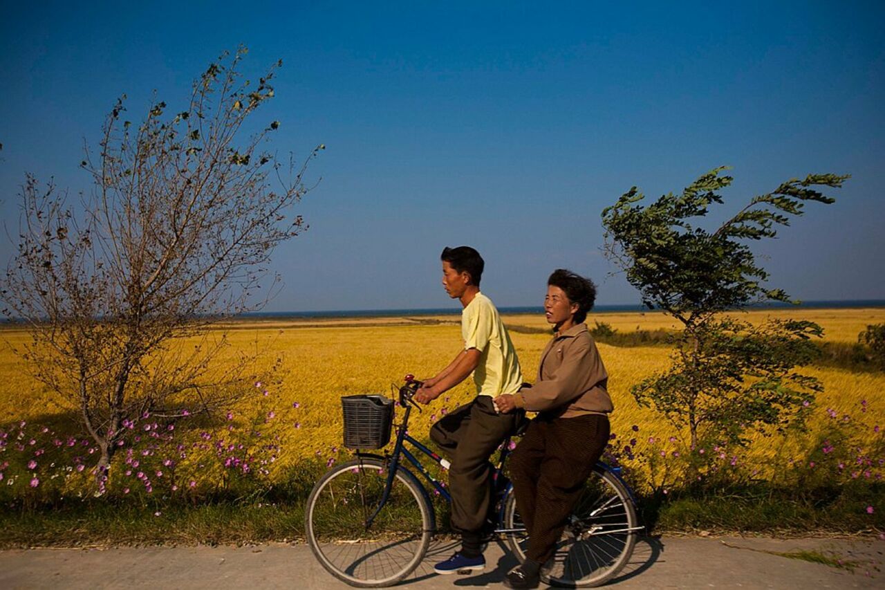 Ехать пешком. Два человека на велосипеде. Вдвоем на велосипеде. Корейцы на велосипедах. Велосипеды Северная Корея.