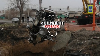 Подъемный кран достал провалившийся в яму автомобиль в Кемерове
